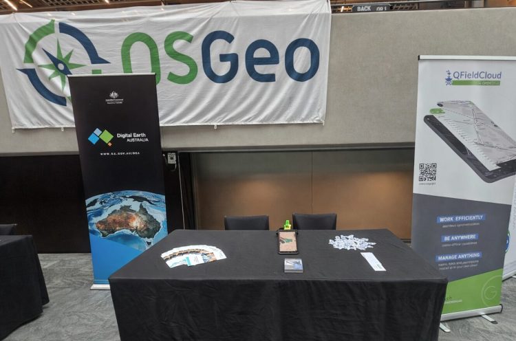 QField booth at FOSS4G 2025 Auckland with Happy Mini Q GNSS integration on display